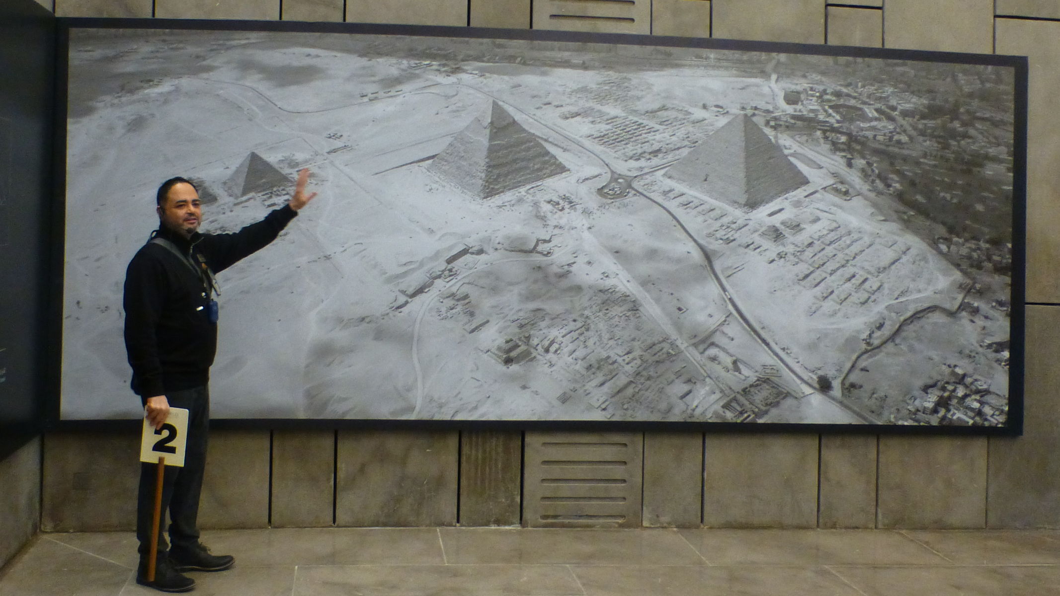 Our Egyptologist, Tarek, pointing to the location of the discovery of the solar boats near the Pyramid of Menkaure. (BTW in this picture you can see many of the roads and other infrastructure built to accommodate tourists.)