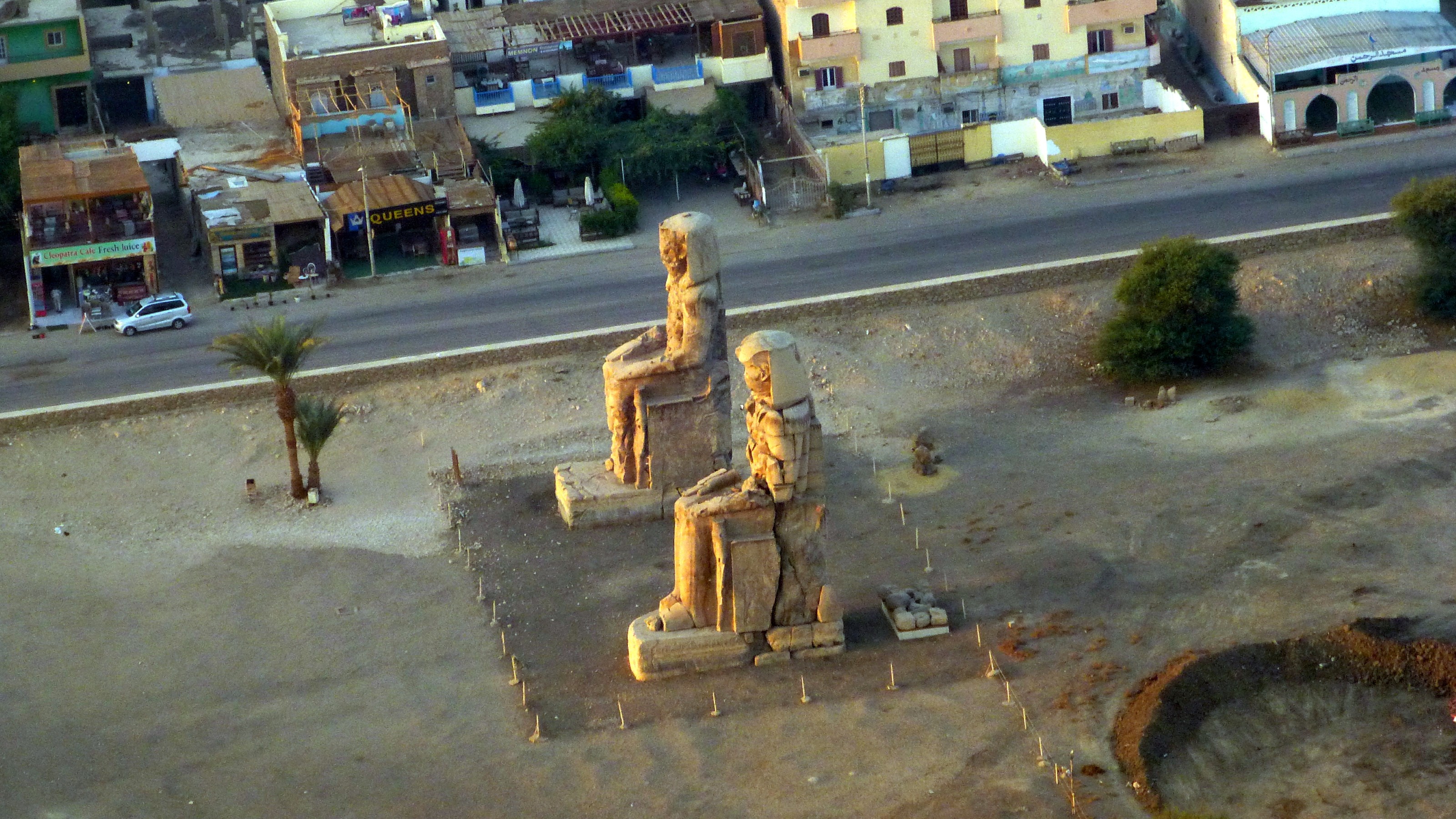 Two seated statues mark the side of a new dig.