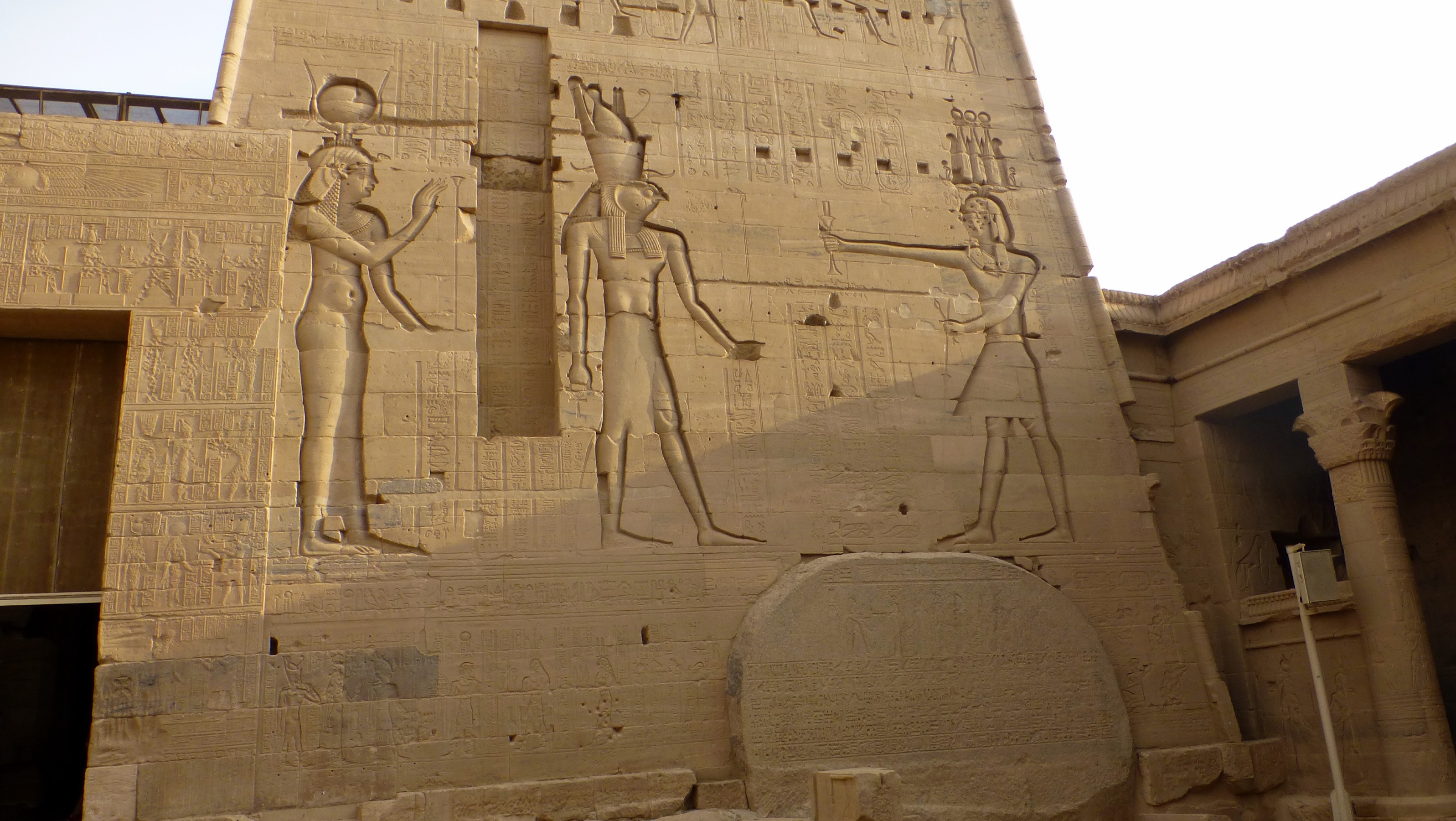On the left is Hathor (you can tell from her cow horns with the sun in the middle) and her husband Horus. Not sure who is on the right.