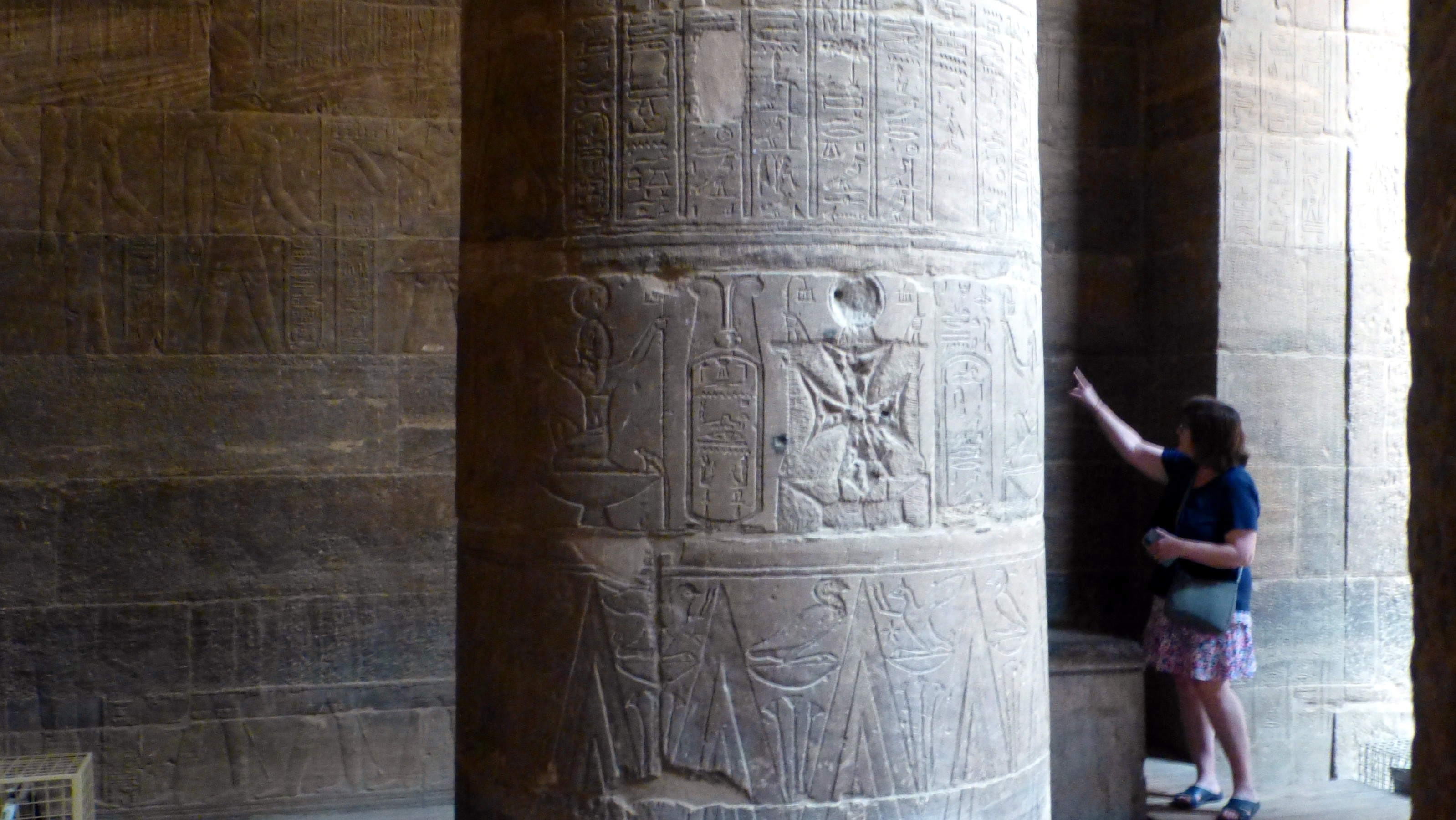 A cross carved into a pillar. (And that is not short woman pointing to the cross. Just a trick of perspective.)