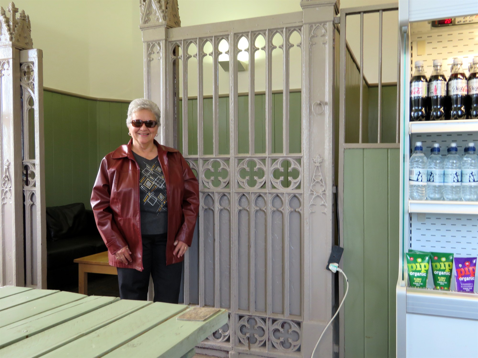 Cissy standing in front of one of the horse stalls. It now serves as a seating area in the Cafe