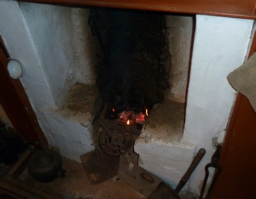 The Blackhouse hearth with a warm peat fire.