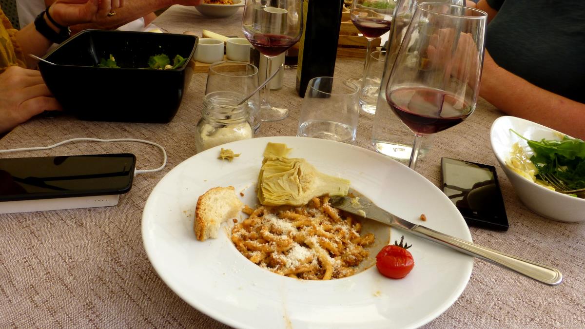 A fine meal of pici with bolognese, artichokes, bread and a glass of vino